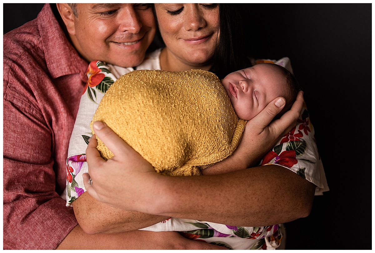 Newborn Session with Family Portraits before session. Beautiful baby boy in a yellow wrap, with mom & dad , Photographs by Bokeh Love Photography.