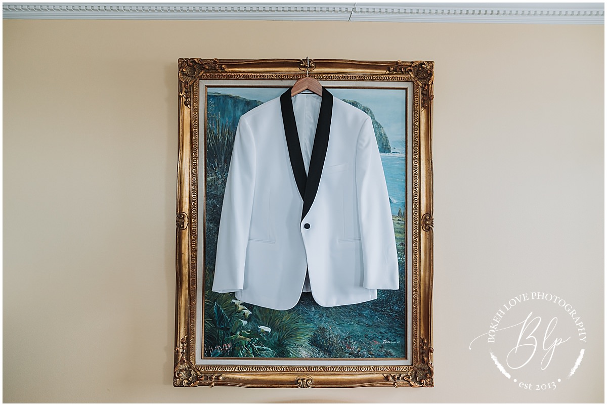 Photography by Bokeh Love Photography, Grooms suite jacket hanging on a fram at the Flanders Hotel in Ocean City