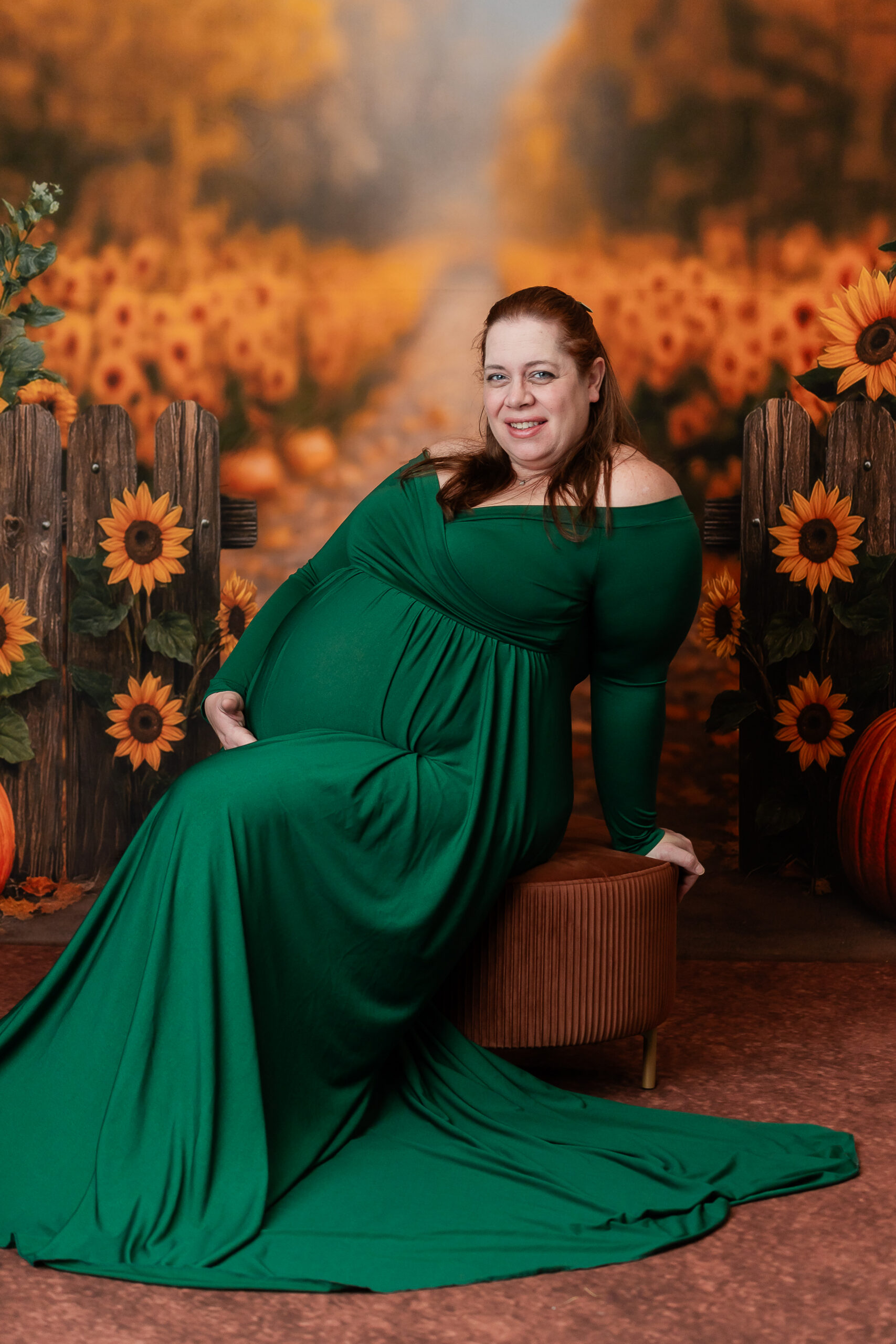 Pregnant mother photographed on a yellow sunflower backdrop during a cozy indoor maternity session in South Jersey, creating a warm and vibrant look.