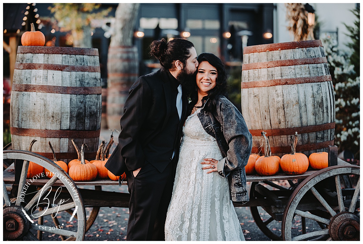 Bride and Groom Portraits Renault Winery. Photo by Bokeh Love Photography. October Wedding. Pumpkins on wagon at Renault Winery. Rustic Wedding Portraits.