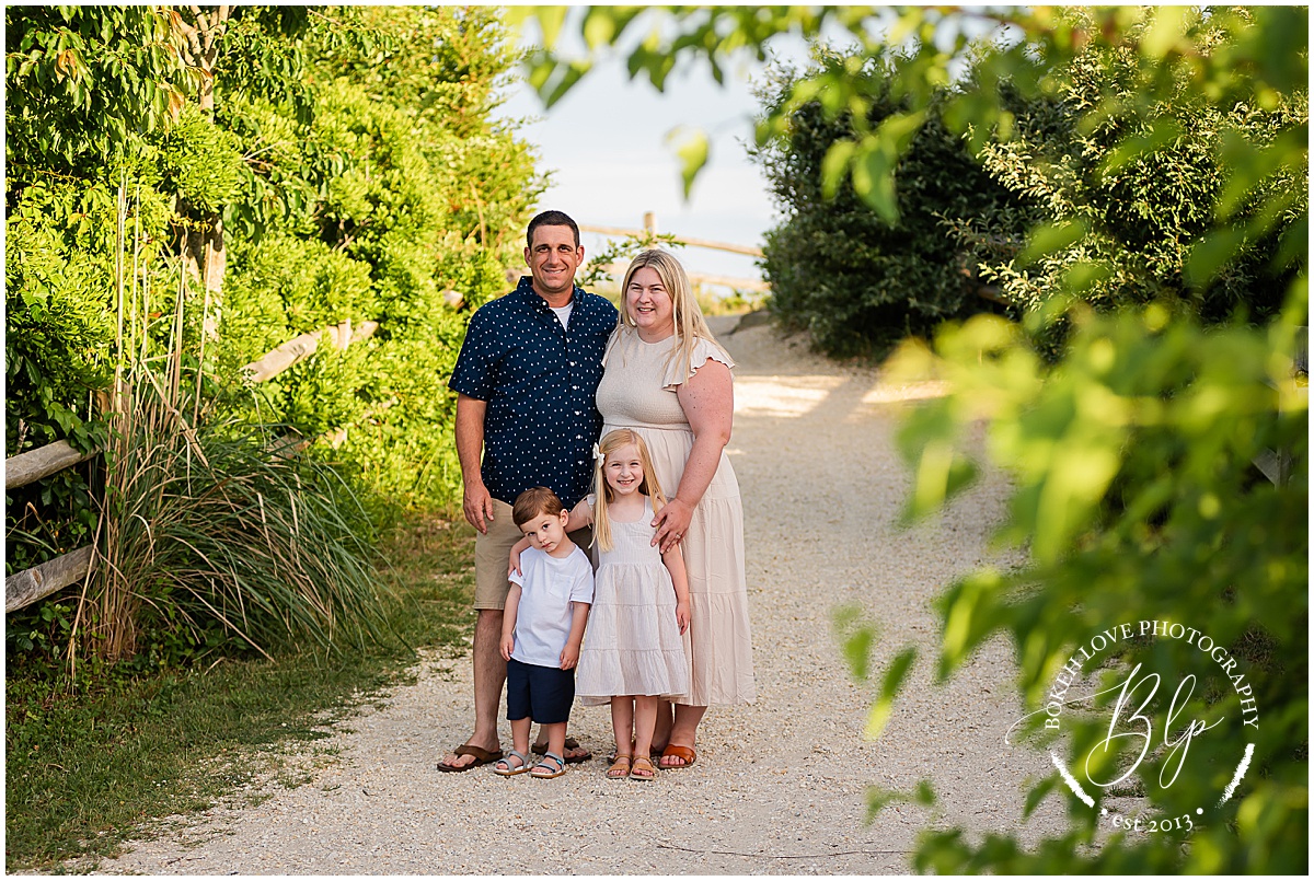 Bokeh Love Photography, Family of 4 at the cape may lighthouse, on beach path with beautiful greenery around them, Cape May Lighthouse Family Portraits, Bokeh Love Photography